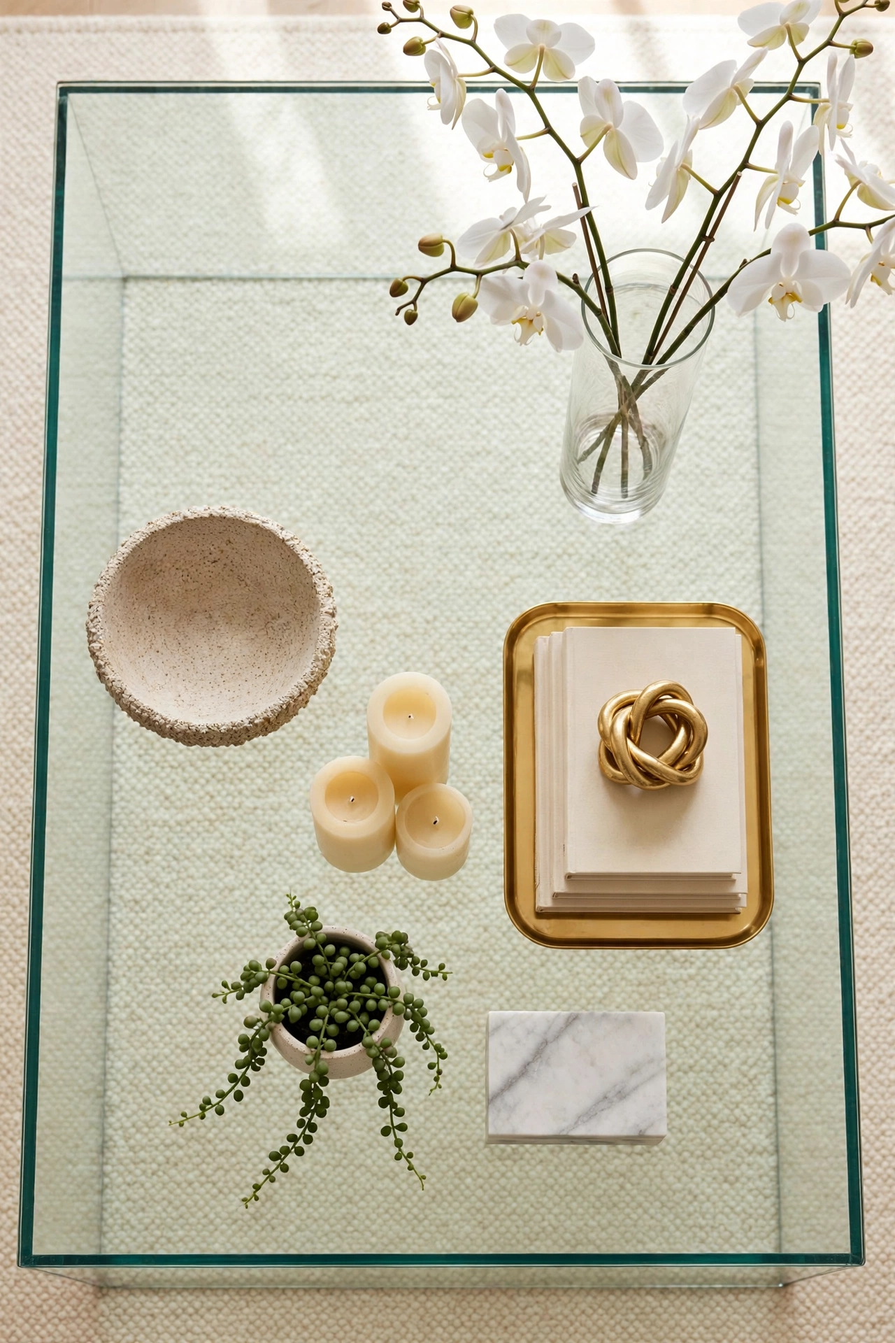 Finished styled coffee table photographed from above showing balanced heights, one hero piece, and calm empty space